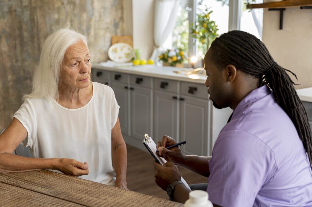 Care professional with a clipboard doing an in-home care assessment with a senior woman